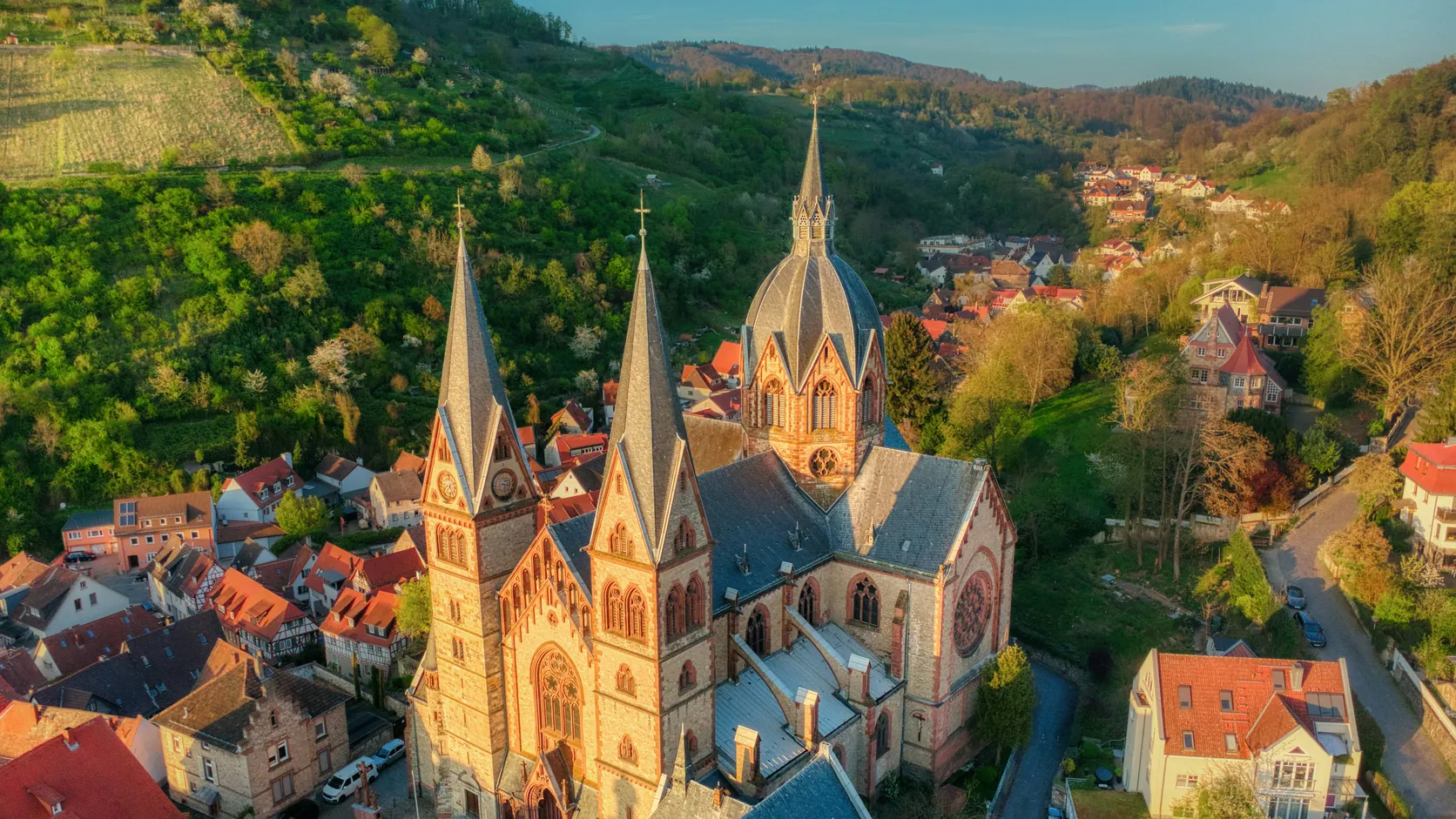 Blick von oben über Heppenheim, in der Mitte die Kirche, dahinter die Hügel des Odenwalds.